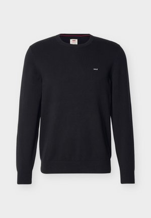 Musta pitkähihaisen neulepuseron, jossa on pieni valkoinen Levi's-logo vasemmassa rinnassa sekä resorit hihansuissa ja helmassa.