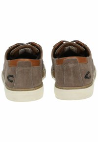 Zapatos de ante marrón con un acento de cuero tostado, presentan una suela de goma blanca, forma redondeada y un logotipo negro en el talón.