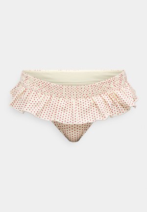 Krémové bikiny s červenými bodkami a volánikmi. Má nariasený pás a rozšírené volánové detaily pozdĺž horného okraja.