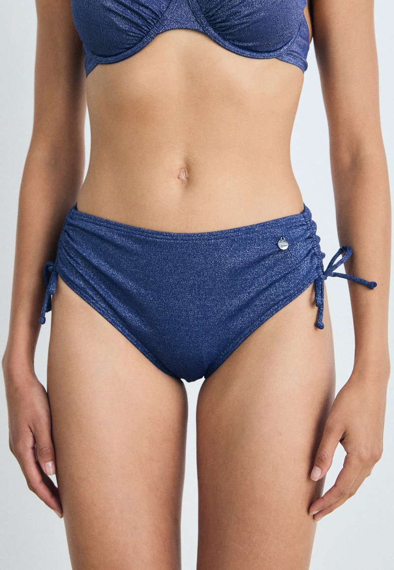 Parte de baixo de biquíni de cintura alta azul marinho com uma textura cintilante, laços laterais e detalhes de franzido nas laterais. Pequeno logotipo metálico como destaque.