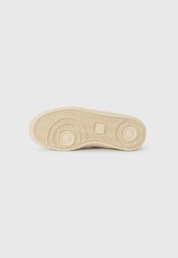 Suola di scarpa in gomma beige chiaro con motivi a zigzag e circolari, marchiata con il testo "VEJA" al centro del quadrato.