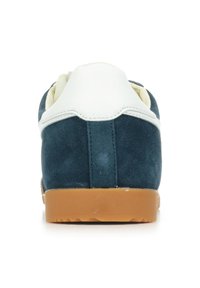 Sneaker in suede verde scuro con dettagli in pelle bianca e suola in gomma naturale. La vista posteriore mostra un tacco arrotondato e dettagli di cucitura.