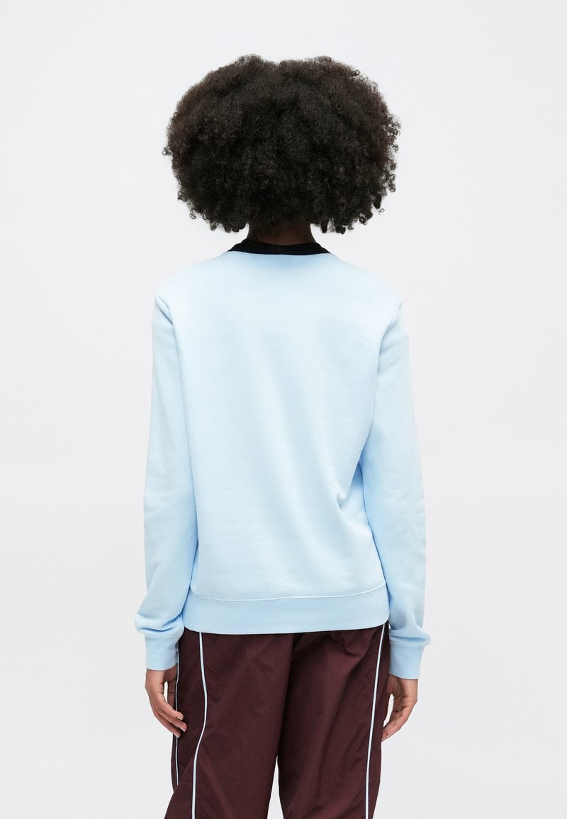 Sweatshirt bleu clair avec un col rond et des bordures noires, présentant une texture lisse et des poignets côtelés, vu de dos.