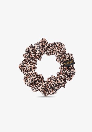 Chouchou en imprimé léopard en tissu lisse, avec un design froncé en beige et taches noires, et une petite étiquette de logo noire.