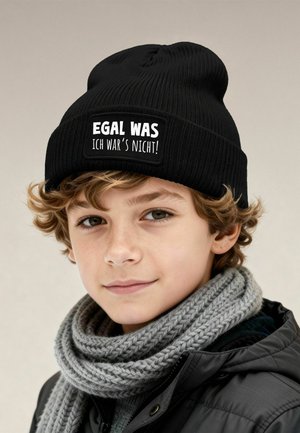 Black knitted beanie with a rectangular patch displaying white text: “EGAL WAS ICH WAR'S NICHT!” paired with a gray knitted scarf.