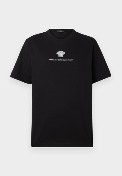 Črna bombažna majica s belim grafikonom glave Meduze in besedilom "VERSACE VIA GESÙ 12 MILANO" v elegantni pisavi na prsih.