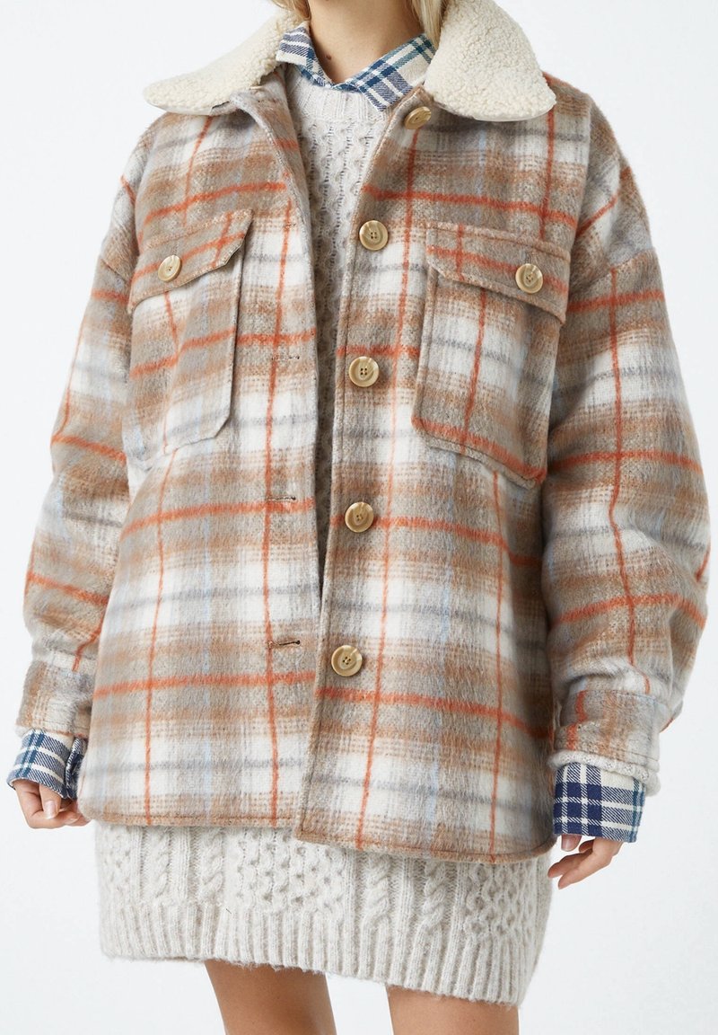 Giacca in misto lana a scacchi con motivi beige, arancioni e blu, dotata di un morbido colletto in sherpa, bottoni sul davanti e due tasche sul petto.