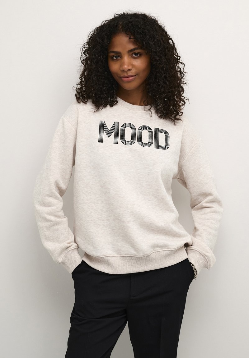Ljusgrå sweatshirt med "MOOD" tryckt i svart, med rund halsringning, långa ärmar och ribbade manschetter. Bärs med svarta byxor.