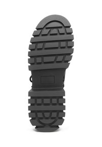 Suela de zapato de goma negra con una banda de rodadura texturizada y multi patrón para mayor agarre. Incluye un diseño robusto con elementos curvos y angulares.