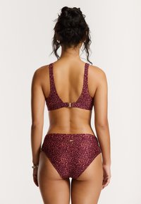 Maroon bikini with a textured, leopard print design. Features a low back, wide straps, and a clasp closure at the back of the top.