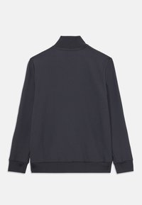 Marinblå tröja med lång ärm och hög krage, ribbad mudd och nederkant, slät textur och minimalistisk design som visar en enfärgad nyans.