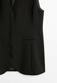 Gilet noir sans manches ajusté avec col cranté et deux poches horizontales sur le devant sur fond blanc.