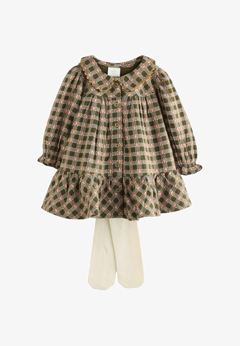 Zaļš plāns kleita ar ziedu akcentiem, frillētu apakšmalu un apkakli; kombinēta ar krēma krāsas zeķbiksēm. Iezīmē pogu aizdare un pūkainas piedurknes.