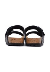 Sandali neri con due cinturini regolabili, soletta in sughero e suola in gomma testurizzata. Il design aperto sul retro consente una facile vestibilità.