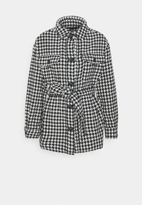 Giacca con motivo pied de poule bianco e nero, vita cinturata, due tasche frontali e chiusure con bottoni, con scollo a collo.
