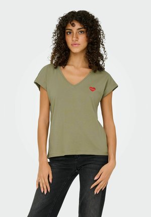 Oliwkowa koszulka z dekoltem w serek, wykonana z miękkiego materiału, z krótkimi rękawami i małym czerwonym serduszkiem na lewej stronie klatki piersiowej.