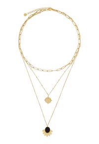 Goldfarbene, mehrlagige Halskette mit einer flachen Gliederkette, einer zarten Kette mit einem runden Anhänger und einem Sonnenblumenmotiv mit schwarzem Zentrum.