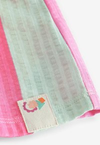 Tissu rayé en rose et vert clair avec surface texturée. Comprend une étiquette carrée avec un motif géométrique coloré.