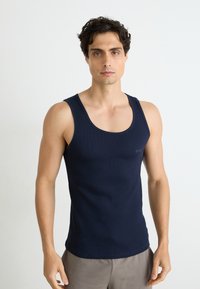 Marineblaues, geripptes Tanktop aus Baumwolle mit Rundhalsausschnitt und slim fit. Dezentes Markenlogo auf der linken Brust.