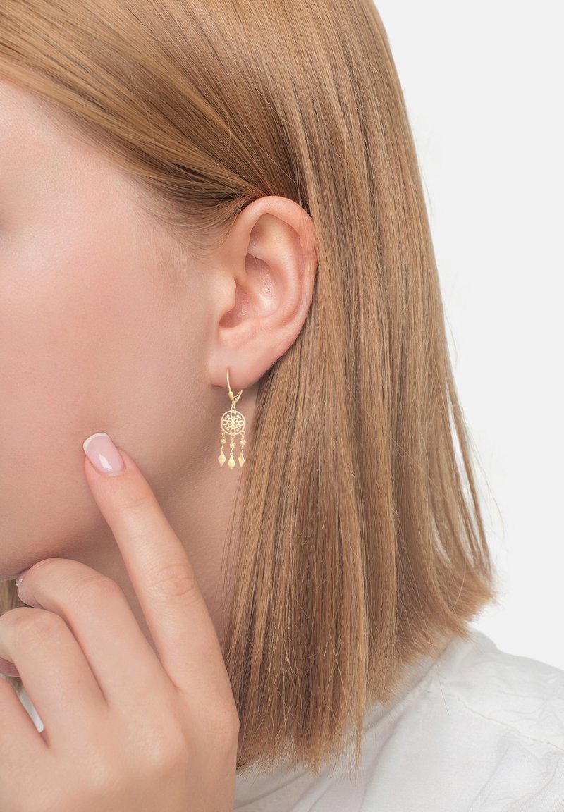 Guldörhängen med en cirkulär charm som har delikata utskurna mönster och tre geometriska hängen som hänger nedanför.