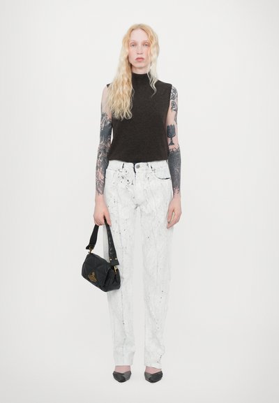 Brown sleeveless top, white textured pants with paint splatter, black handbag, and gray pointed flats. Tattoos visible on arms.