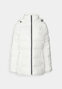 Vit pufferjacka med huva. Har ett diagonalt quiltat mönster, främre dragkedjestängning och en liten logotyp på bröstet.