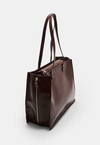 Borsa tote in pelle marrone con finitura lucida, dotata di due manici lunghi, zipper esposta e un design strutturato.
