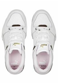 Weiße Ledersneaker mit durchbrochenen Details, flachen Schnürsenkeln, goldenen Logoakzenten und gepolstertem rosafarbenem Innenraum. Gummisohle für besseren Halt.