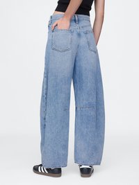 Bredde ben blå denimbukser med høy midje, med to baklommer og frayed kant. Jevn tekstur med en klassisk lys vaskefinish.