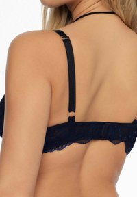 Czarny biustonosz z koronką, posiadający regulowane ramiączka, dekoracyjną lamówkę oraz zapięcie na haftkę, prezentujący gładką fakturę.