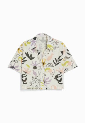 Chemise à manches courtes boutonnée avec des imprimés abstraits et botaniques colorés sur un fond clair, comportant des éléments de texte ressemblant à des phrases.