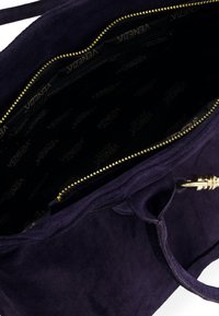 Navy modrá suede kabelka se zlatým zipem, s vnitřním vzorem značky "VENEZIA," která se pyšní prostorným a jemným texture.
