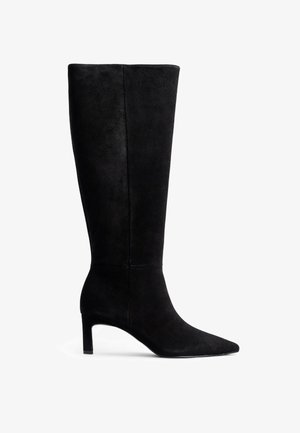 Mustmustest musta kõrge varrega saapad terava ninaga ja saleda stiletto kontsaga. Siidine tekstuur puhta disainiga, kus puuduvad nähtavad metallosad või aksessuaarid.