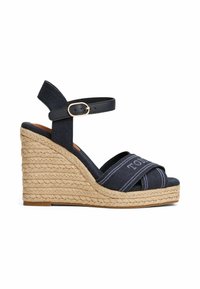 Wedge sandal with a woven jute heel, navy canvas upper, ankle strap with gold buckle, and cross-band design featuring logo accents.