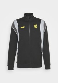 Svart zip-up jacka med grå accentpaneler. Har en ståkrage, ribbade mudd, Puma-logotyp och Borussia Dortmund-märke i gult.