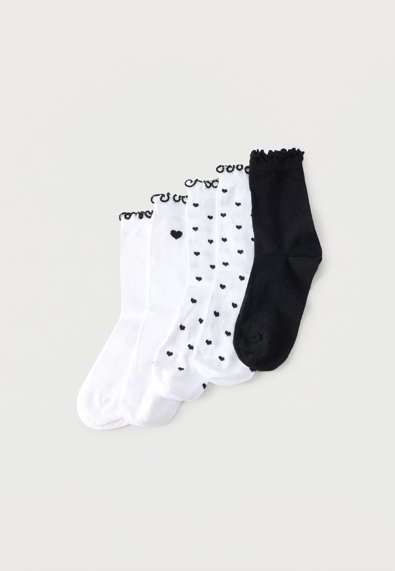Cinq paires de chaussettes montantes avec bordure noire froncée, trois blanches avec motifs de cœurs noirs, une blanche unie, une noire unie.