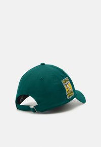 Πράσινο βαμβακερό καπέλο μπέιζμπολ με κυρτή μέση, που διαθέτει μια κεντητή ετικέτα στο πλάι. Ρυθμιζόμενη υφασμάτινη θηλιά στο πίσω μέρος.