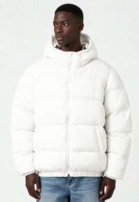 Giacca trapuntata bianca con cappuccio, dotata di chiusura con zip e tasche laterali. Tessuto trapuntato ed orlo elastico per una migliore vestibilità.