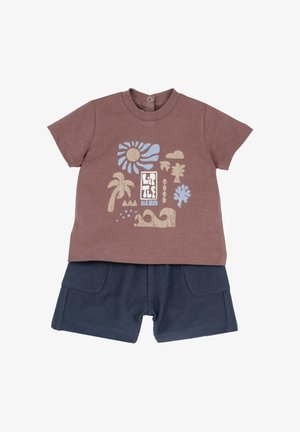 Tenue pour tout-petit avec un t-shirt marron à motif représentant le soleil, des palmiers, des nuages et des vagues, associée à un short bleu marine texturé avec des poches avant.