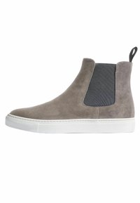 Botines de ante gris con panel lateral elástico negro, suela de goma blanca y tira en la parte posterior; acabado suave y líneas limpias.