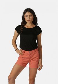 T-shirt noir à manches courtes associé à un short corail avec fermeture à bouton et à zip, poches latérales, et une texture lisse.