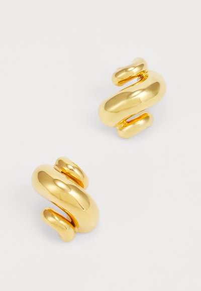 Pendientes de metal en tono dorado con un diseño escultórico y en espiral que presenta superficies lisas y reflectantes, así como diferentes grosores en toda su extensión.