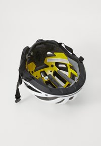 Weißer und schwarzer Fahrradhelm aus der Vogelperspektive, mit einer gelben Innenschale, verstellbaren Riemen und Belüftungsöffnungen.