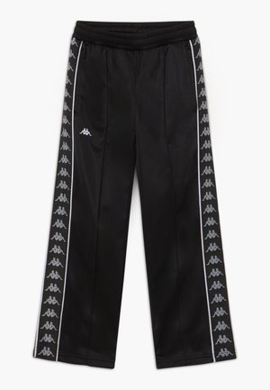 Pantaloni da jogging neri con vita elastica, tasche laterali e striscia bianca con logo che presenta disegni ripetuti di figure sedute sulle gambe esterne.