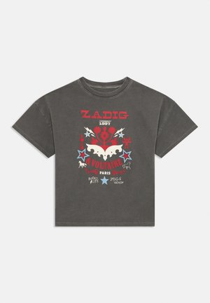 Camiseta de algodón gris con mangas cortas, que presenta un diseño gráfico audaz en rojo, blanco y azul, incluyendo estrellas y motivos de rayos.