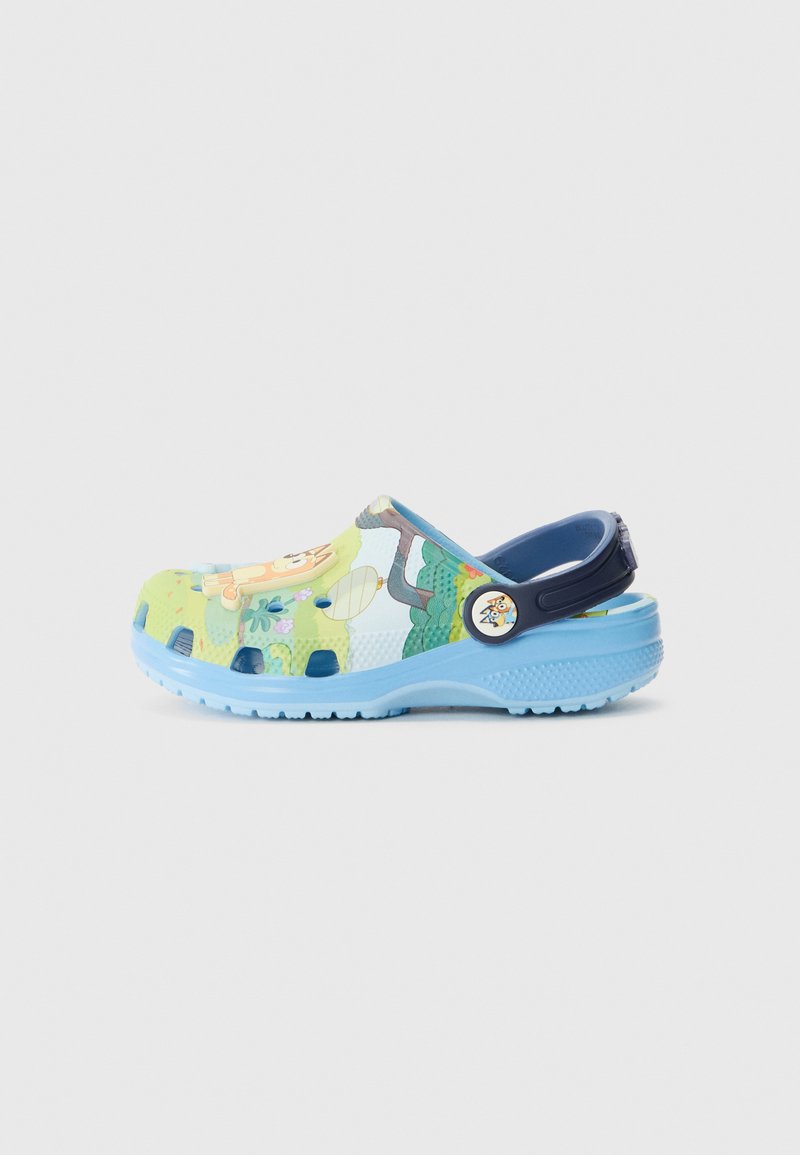 Zoccoli colorati con motivi verdi e blu, caratterizzati da grafiche di animali. Realizzati in materiale resistente con una comoda fascia posteriore e fori di ventilazione.
