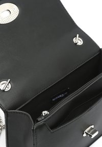 Sac à main en cuir synthétique noir avec un fermoir en argent et une bandoulière en chaîne. Le design comporte une poche intérieure et un compartiment zippé.