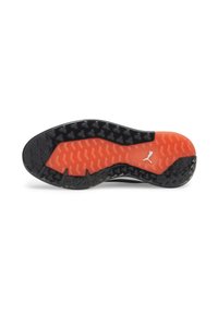 Semelle de chaussure en caoutchouc noire et orange avec grip texturé et petit logo Puma blanc près du centre.