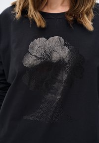 Czarna, długosleeve'owa koszula z graficznym wzorem twarzy w kropki, charakteryzująca się gładkim materiałem i luźnym krojem.