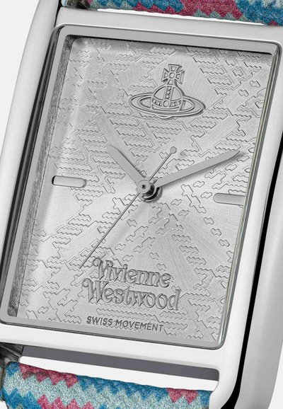 Montre rectangulaire argentée avec motifs gravés sur le cadran, aiguilles et logo argentés. Bracelet textile multicolore avec motif zigzag.
